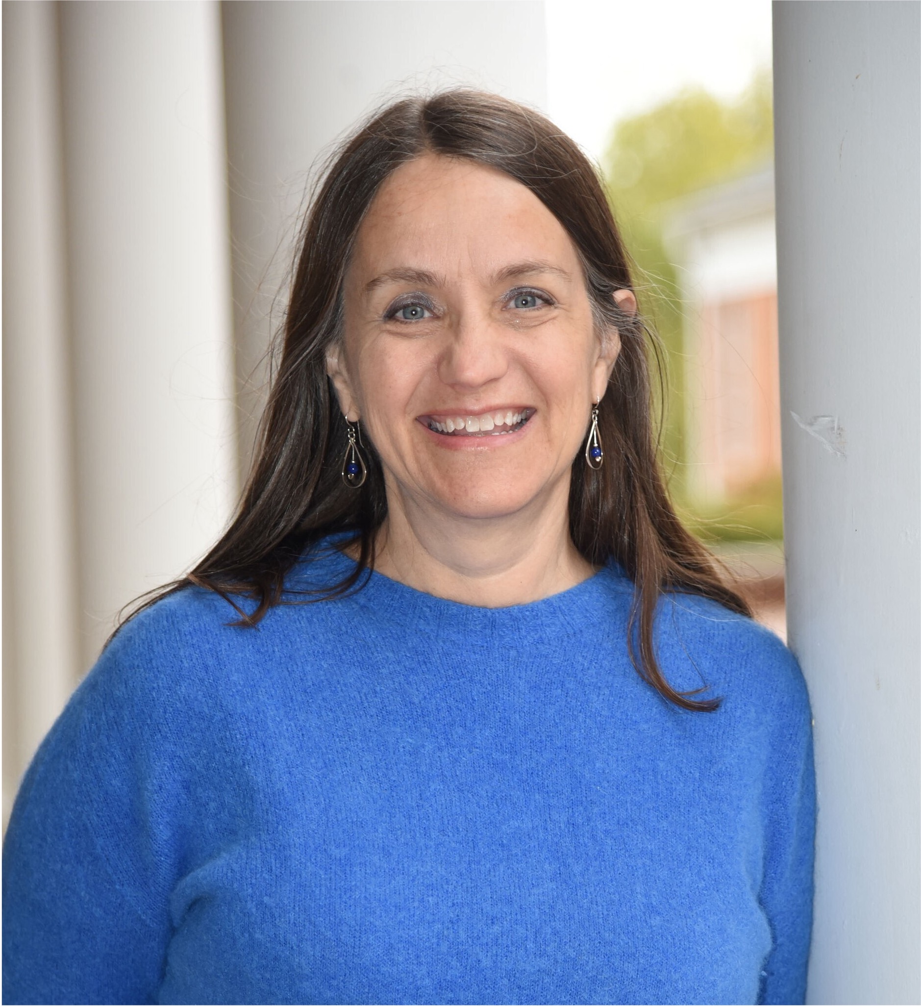 Stacy Klein-Gardner standing and smiling, wearing a blue shirt.