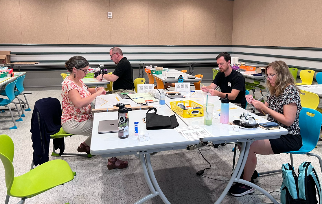 e4usa team and teachers around a table doing activities