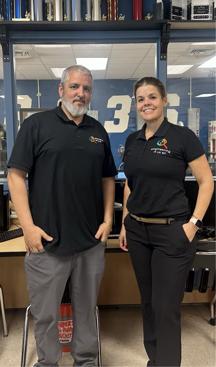 teachers Alex Garrido and Lianet Rodriguez standing next to each other for the photo in computer lab or section of a classroom.