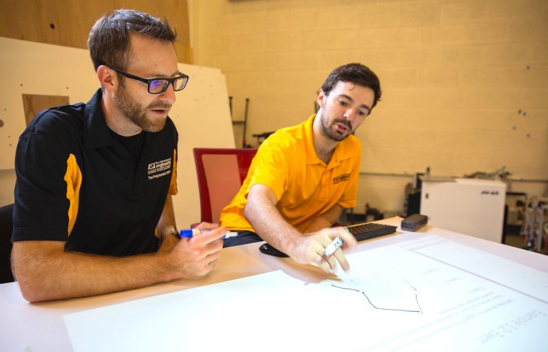 Adam Carberry and graduate student Mason Smith who is using an interactive table he built to assist students with learning.