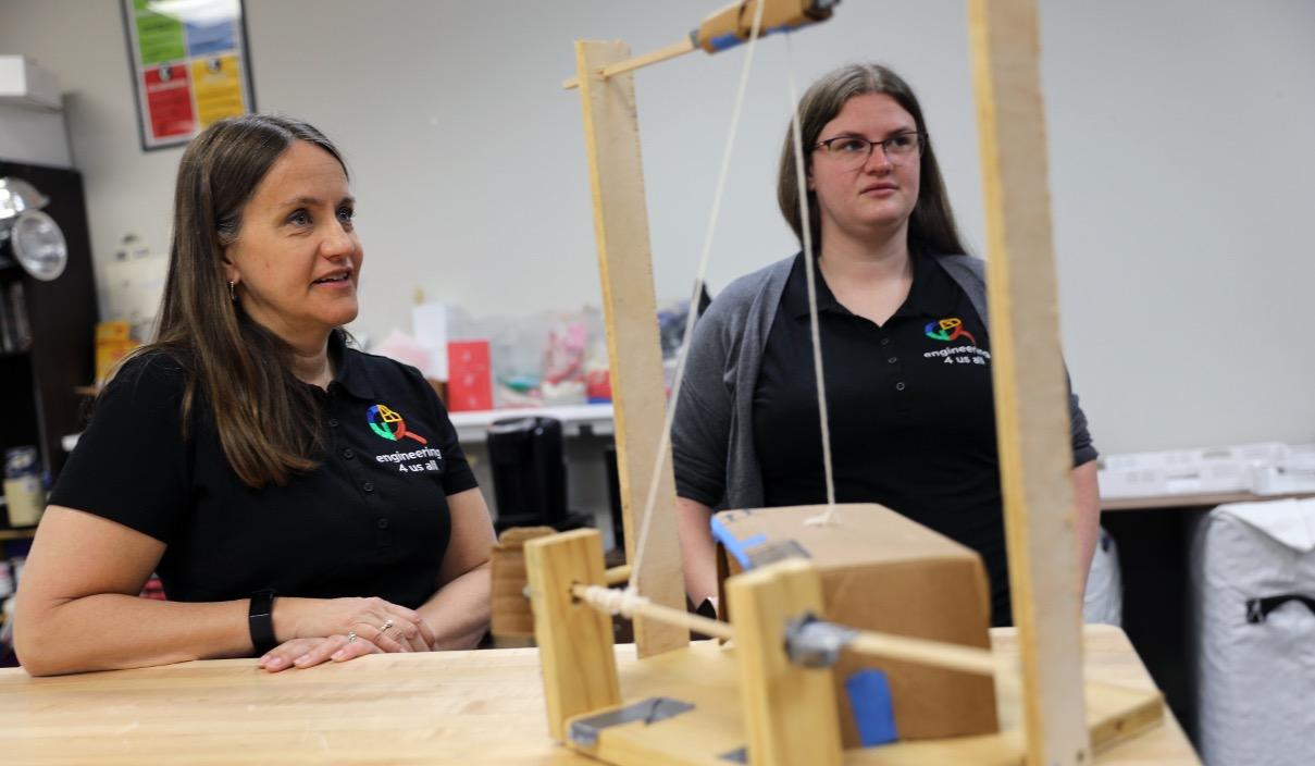 Stacy and Emily around a table with the project prototype