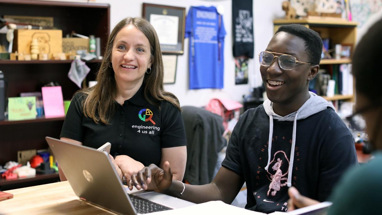 Stacy and a student in the class in front of a laptop