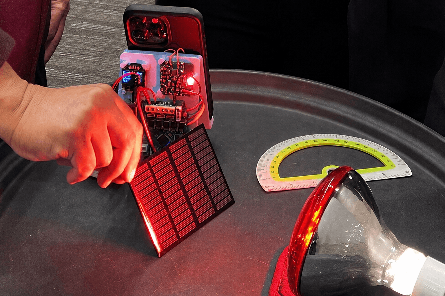 students experimenting on solar panel connected to the charger electronics board