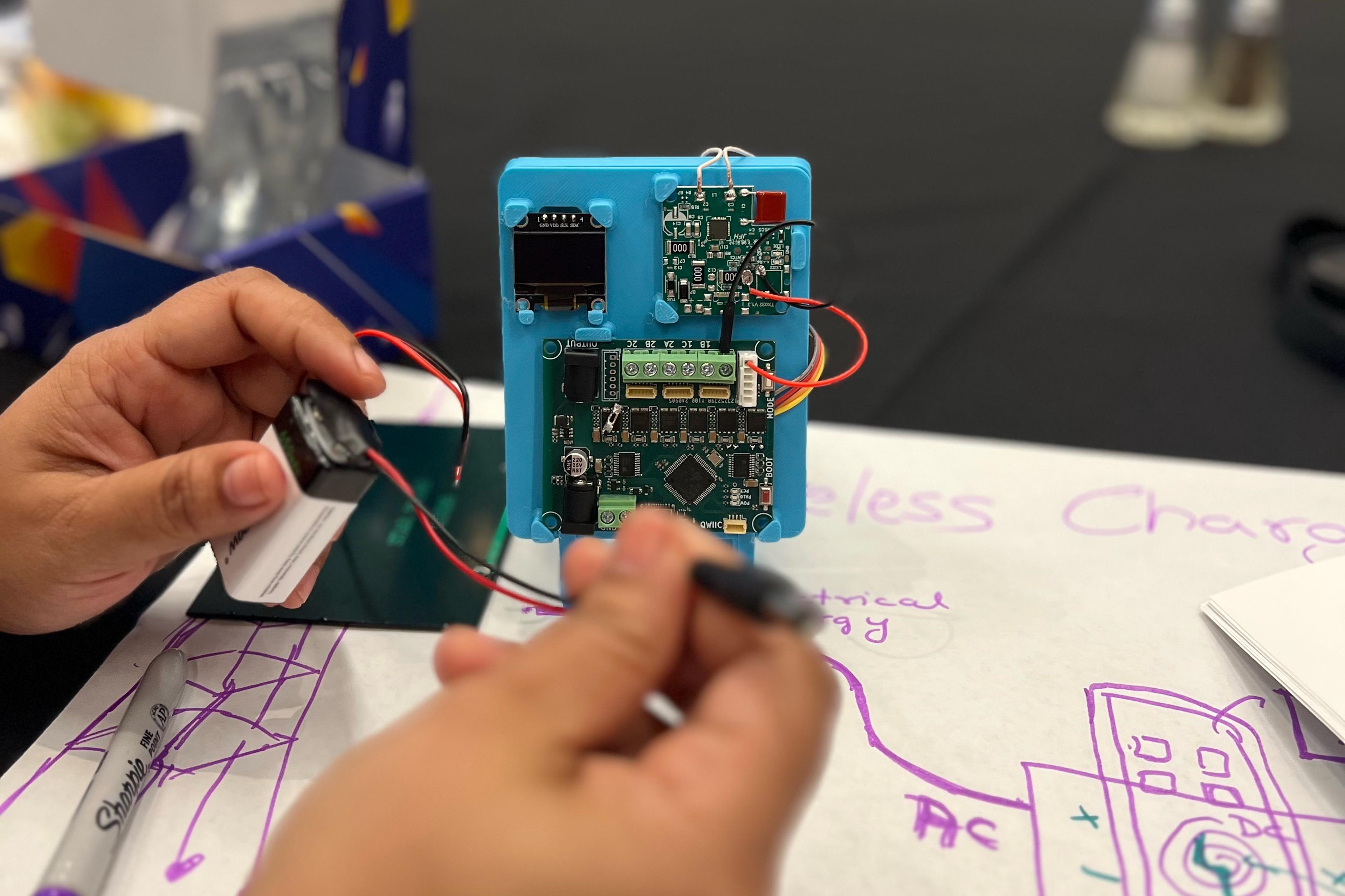 Student working on electronic board of the wireless charger